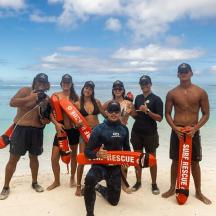 a group of people posing for a picture on the beach