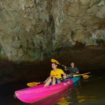 two people in a pink kayak in a cave