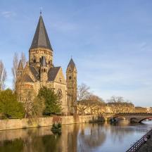 a church with a tower and a bridge over a river