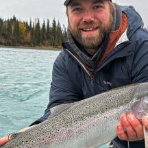 a man holding a fish in his hand on the water