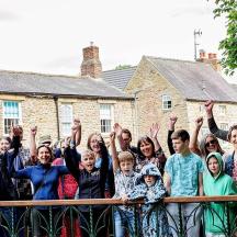 a group of people standing behind a fence