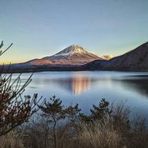 a mountain sitting on top of a body of water