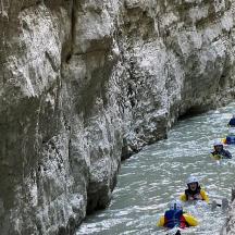 a group of people rafting down a river in a canyon