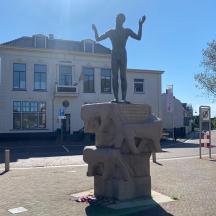 una statua di una donna su una fontana di fronte a un edificio