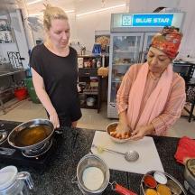 two women standing in a kitchen preparing food