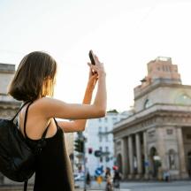 en kvinde tager et billede af en gade med sin mobiltelefon