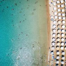 eine Luftaufnahme eines Strandes mit Sonnenschirmen und dem Meer