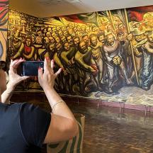 a woman taking a picture of a painting