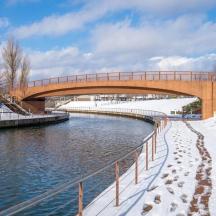 a bridge over a river with snow on the ground