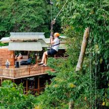 un home en una tirolina a la selva