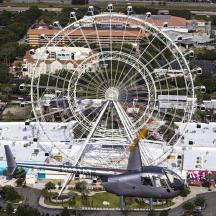 a helicopter is flying next to a ferris wheel