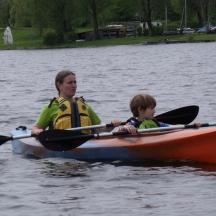 a woman and a child in a kayak on a lake