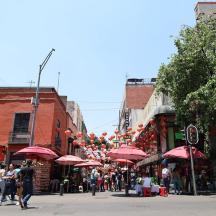 a group of people walking down a city street with umbrellas
