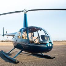 a small blue helicopter sitting on a runway