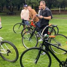 a group of people standing around bikes in a park