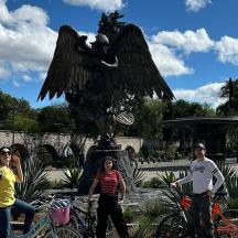 a group of people standing next to a statue of an eagle