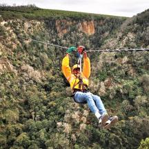 muž visí na zipline na hore