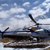 a helicopter parked on top of a snow covered mountain