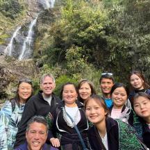a group of people standing in front of a waterfall