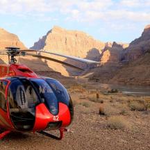 a red helicopter is parked in the desert