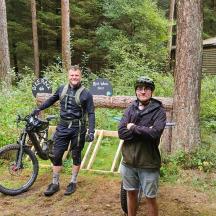 two men posing for a picture with a bike