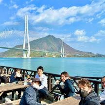 a group of people sitting at tables near the water