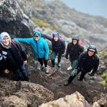 eine Gruppe von Menschen, die auf einem felsigen Berg spazieren gehen