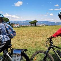 un home i una dona anant en bicicleta en un camp