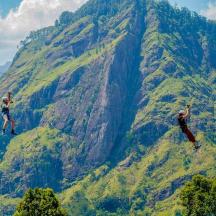 two people are zip lining on a mountain