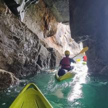 eine Person in einem Kajak in einem Fluss in einer Höhle