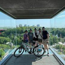 eine Gruppe von Menschen steht mit einem Fahrrad auf einem Glasgebäude