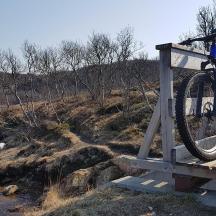 a bike parked on a bridge over a river