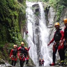 a group of people standing in front of a waterfall