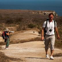 a man walking down a dirt road with a backpack