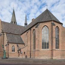una grande chiesa in mattoni con un campanile su una strada