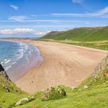 ein Blick auf einen Strand mit Meer und Bergen