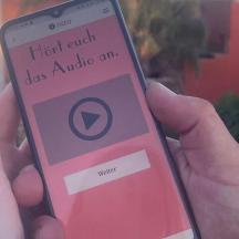 en person som holder en mobiltelefon i hånden