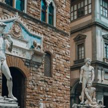 two statues in front of a brick building