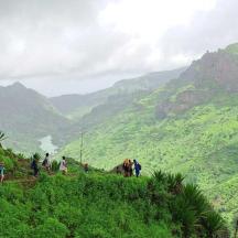 a group of people standing on a hill overlooking a valley