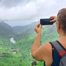 a woman taking a picture of a valley