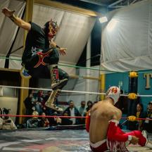 Un hombre con una máscara de pie en un ring de lucha libre.