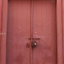 una porta de fusta vermella amb un pany