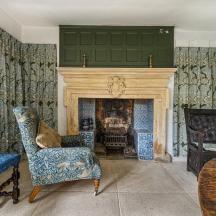a living room with a fireplace and a chair and a table
