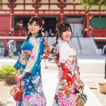 two women in kimonos standing in front of a building