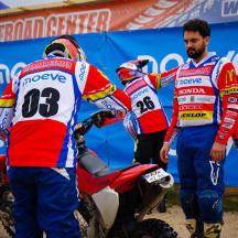 a group of men standing around a dirt bike