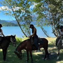 drei Personen reiten auf Pferden in der Nähe eines Gewässers