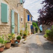 an alley with potted plants on the side of a building