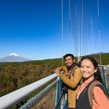 dua orang berdiri di atas dek pemandangan gunung