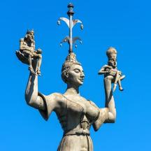 eine Statue einer Frau mit einem Kreuz auf dem Kopf