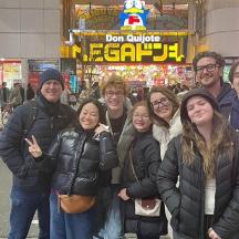 a group of people posing for a picture on a city street